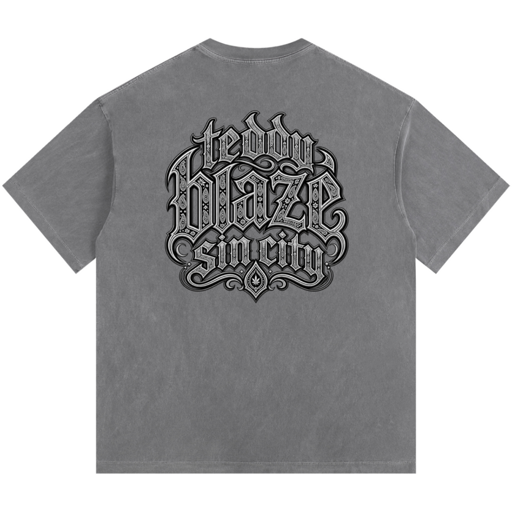 Elevate your casualwear with the Teddy Blaze Sin City Sacred Vintage Washed Cotton Tee. Charcoal gray heavy cotton, vintage wash, tattoo praying hands print, and ornate back graphic. Shop NYC to Vegas style.