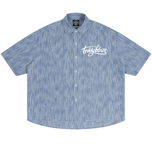 Shop the Signature Boxy Vintage Wash Denim Camp Shirt by Teddy Blaze. 230 GSM lightweight washed blue denim camp shirt with white script branding from HIGH ROLLERS OUTERWEAR.