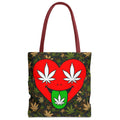 A tote bag with a dark green and brown camouflage leaf pattern, featuring a large red heart graphic on the front with white cannabis leaves for eyes and a green tongue sticking out with a white leaf. The bag has dark red handles.