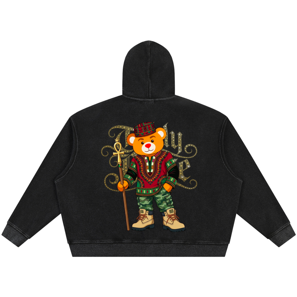 A black cropped hoodie shown from the back, featuring a large graphic of a teddy bear dressed in a red and green military-style uniform with a gold trident and decorative lettering.