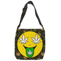 A shoulder bag with a black adjustable strap, featuring a large yellow smiley face graphic with white cannabis leaves for eyes and a green leaf on its tongue, set against a dark green camouflage pattern background.