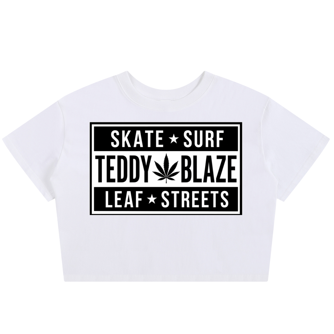 A white short-sleeve crop top t-shirt featuring a black graphic print on the front with the text 'SKATE SURF TEDDY BLAZE LEAF STREETS' and a cannabis leaf icon, displayed on a clean white background.