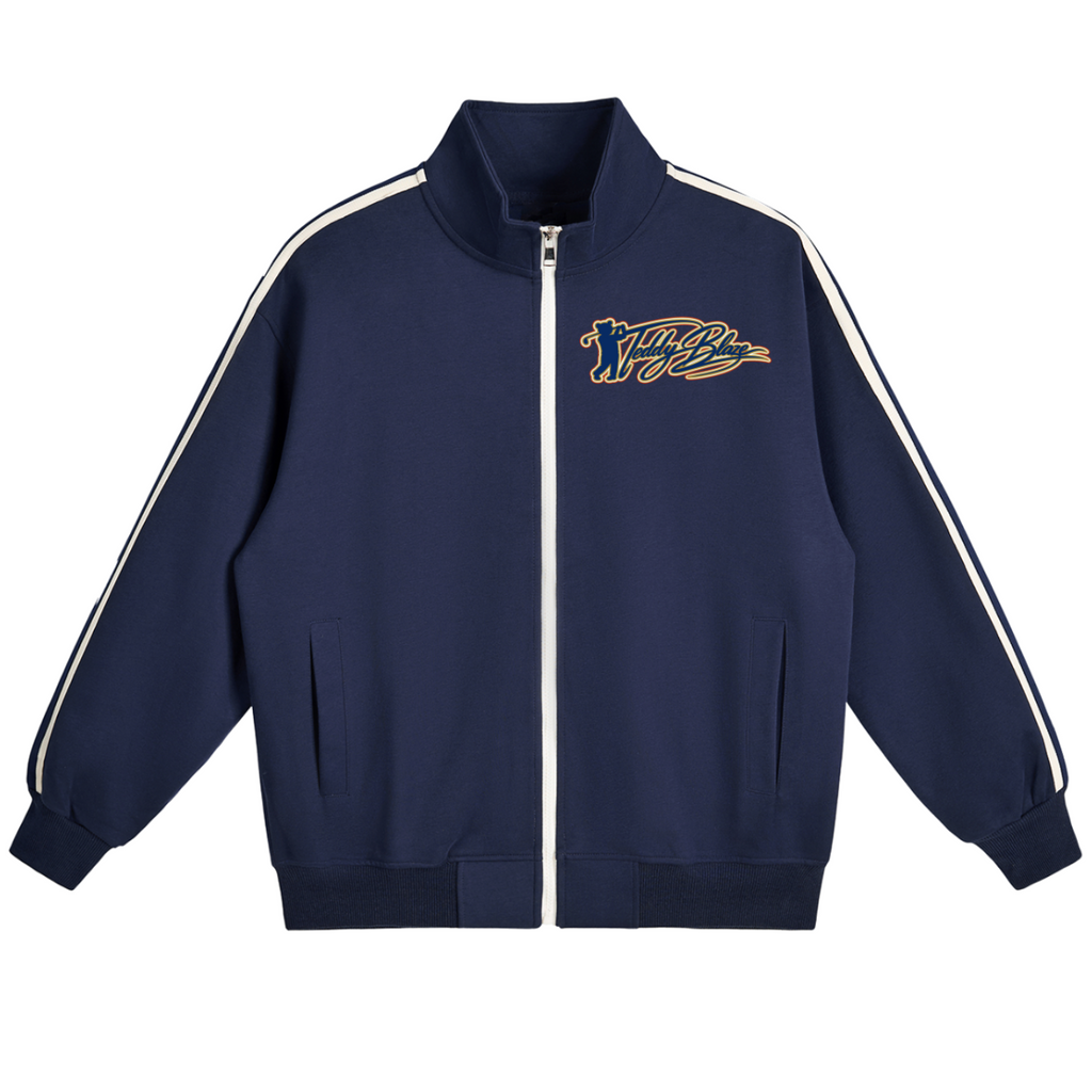 A navy blue zip-up track jacket with white double stripes running down the sleeves and a gold and navy embroidered script logo on the left chest, displayed on a clean white background.
