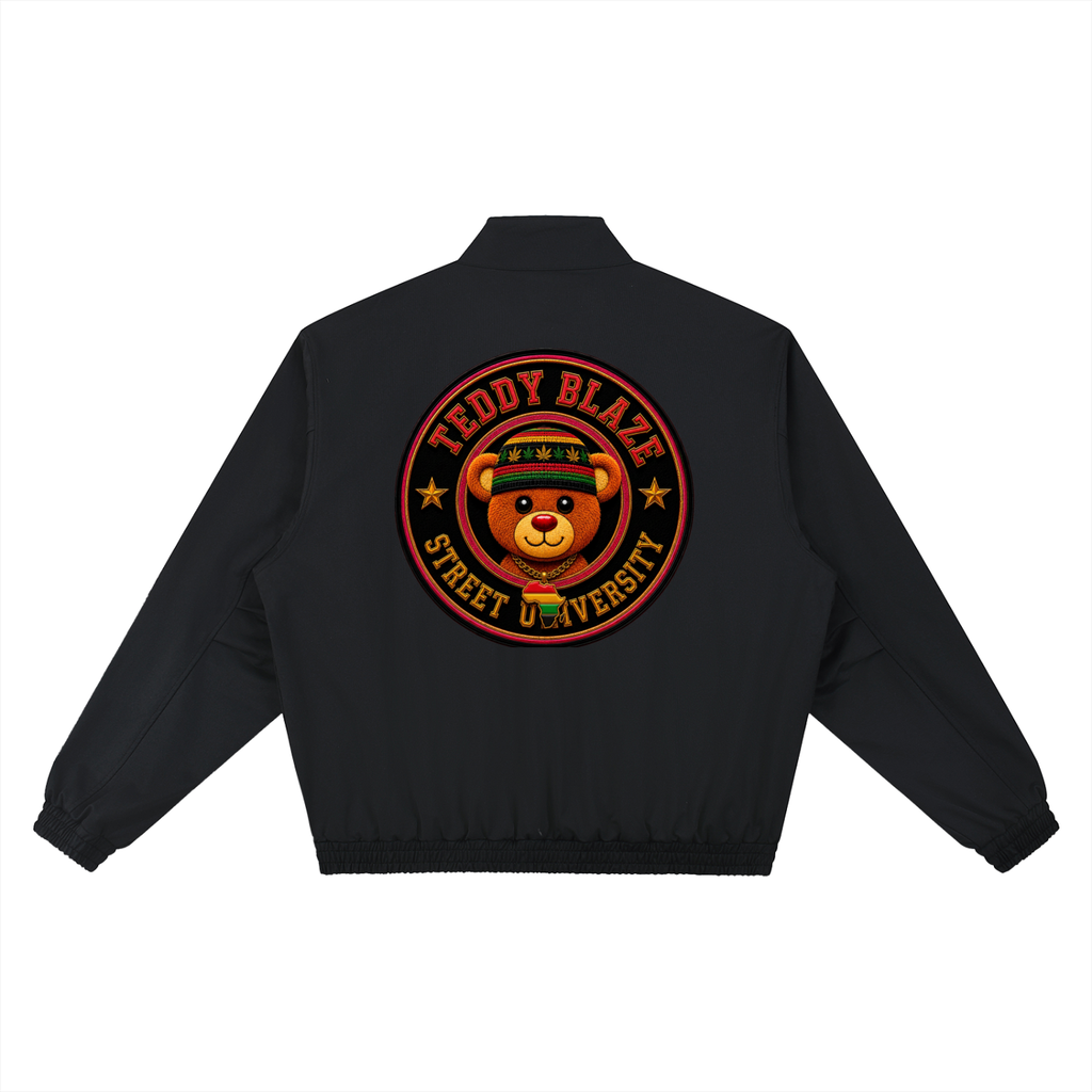 A black bomber jacket shown from the back, featuring a large circular graphic print of a teddy bear wearing a graduation cap with the text 'TEDDY BLAZE' and 'STREET UNIVERSITY'.