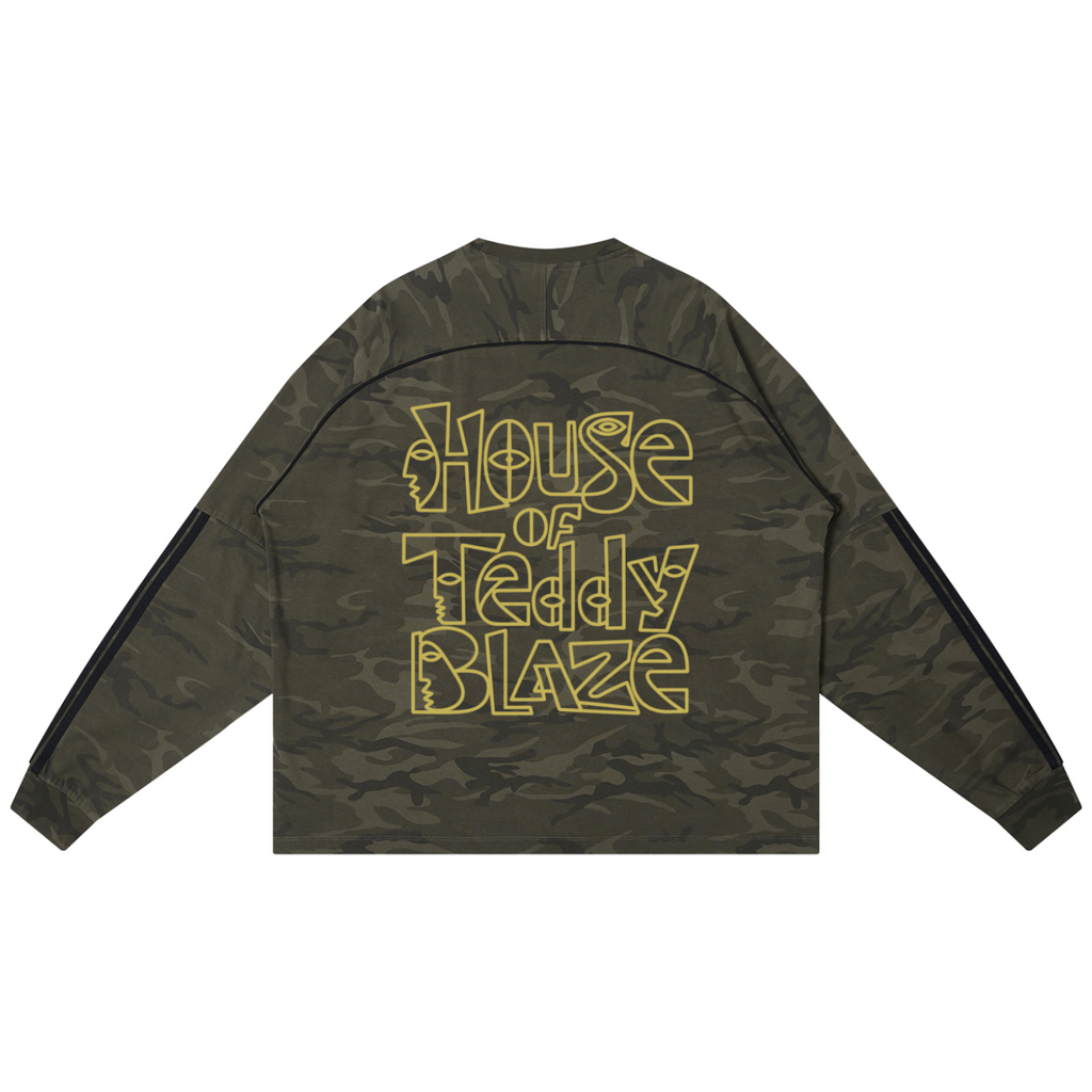 A long-sleeve crop top in an olive green camouflage pattern, featuring the text 'House of Teddy Blaze' printed in a stylized yellow outline font across the back. The sleeves have black stripes down the sides.