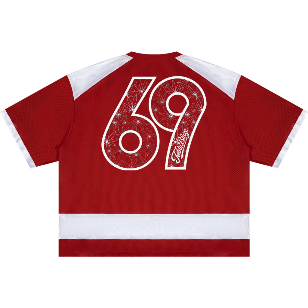 A red short-sleeve hockey jersey shown from the back, featuring a large white number 69 with a star pattern and the word 'Timmins' in script, plus white shoulder panels and a white horizontal stripe near the hem.