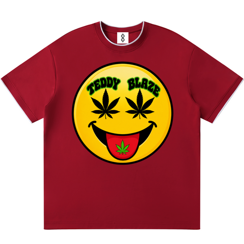 A red short-sleeve crewneck t-shirt featuring a large yellow smiley face graphic on the chest. The graphic has marijuana leaf eyes, the text 'TEDDY BLAZE' in black, and a red tongue with a green leaf detail.