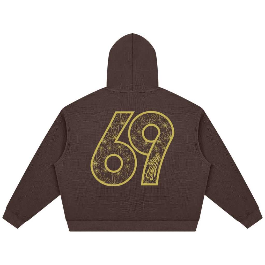 A dark brown cropped hoodie shown from the back, featuring a large gold graphic of the number 69 with floral line art and a script logo on the back.