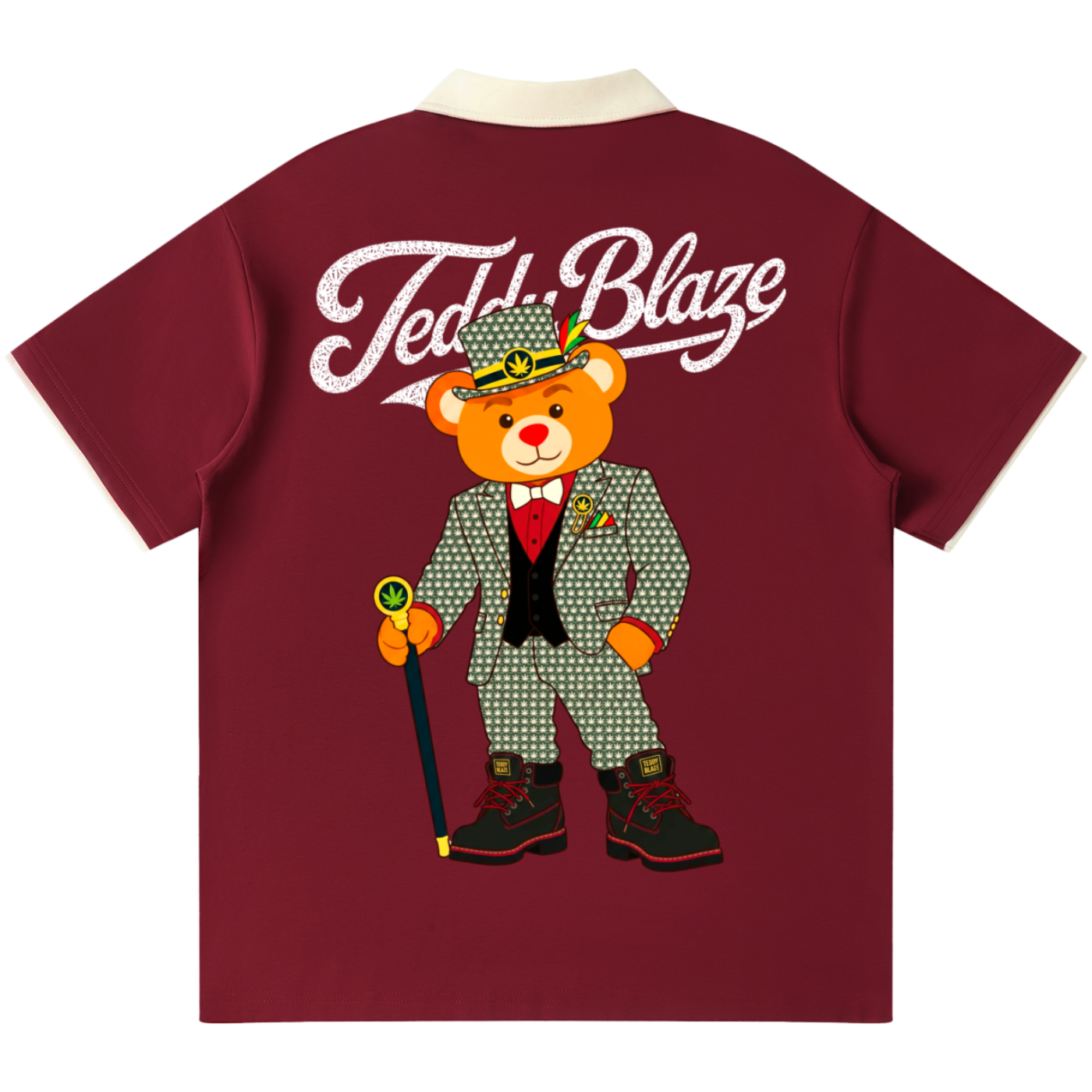 A maroon short-sleeve t-shirt with a cream collar, featuring a large graphic of a teddy bear in a green patterned suit and hat with the text 'Teddy Blaze' printed in white across the upper back.