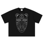 A black short-sleeve crop top t-shirt featuring a white line art graphic of an African tribal mask on the front, displayed flat against a solid white background.