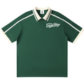 A dark green short-sleeve polo shirt with cream-colored ribbed trim on the collar, sleeve cuffs, and shoulders, featuring a white 'Freddi Blogo' script logo on the left chest.
