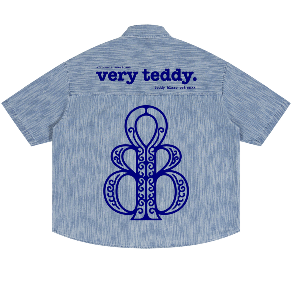 Discover the Teddy Blaze Afrodemia Boxy Vintage Wash Denim Camp Shirt, featuring Afrocentric graphics, a relaxed unisex fit and Afrodemia Americana detailing.