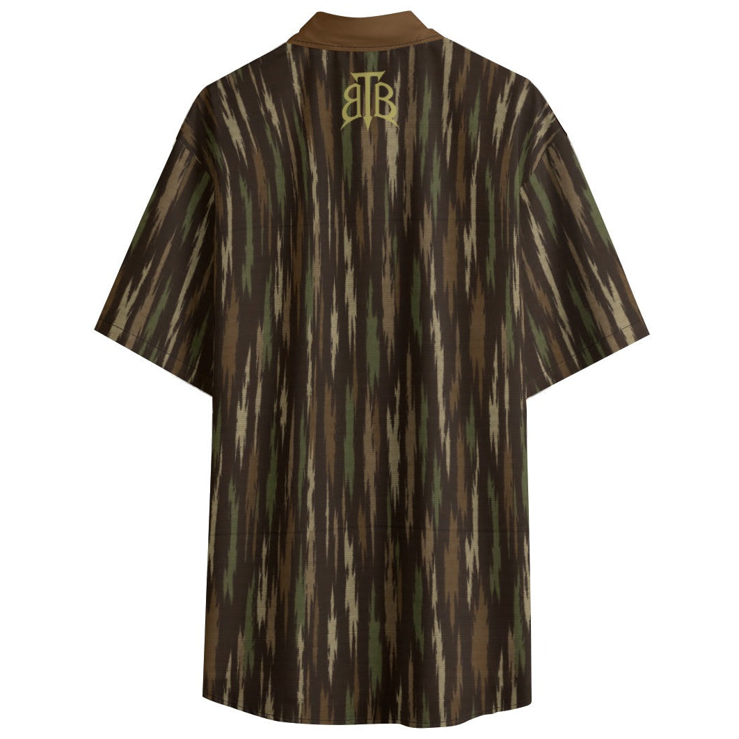 A short-sleeve collared shirt with a vertical ikat-style pattern in brown, olive green, and beige, featuring a gold monogram logo on the back neck, shown against a plain white background.