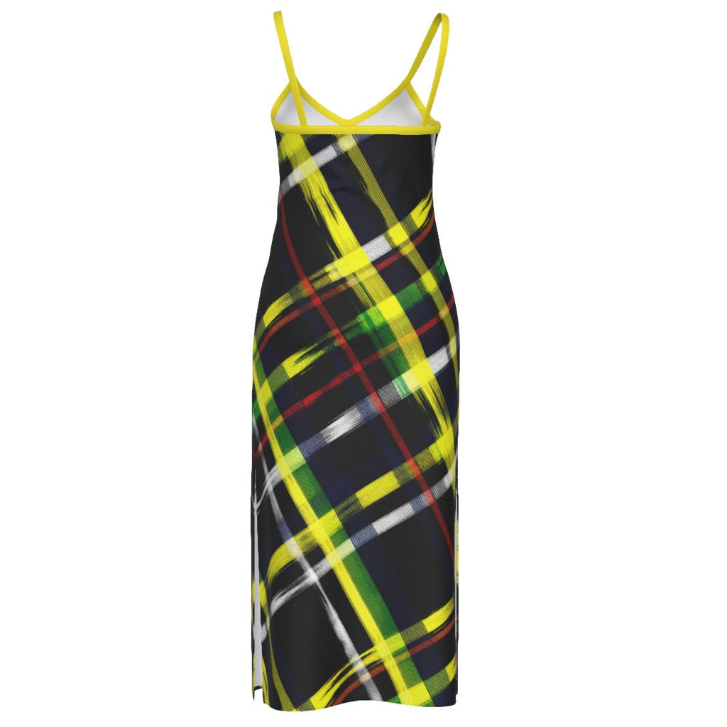 A sleeveless slip dress with thin straps, featuring a black background with a vibrant yellow, green, red, and white plaid pattern, shown against a plain white background.