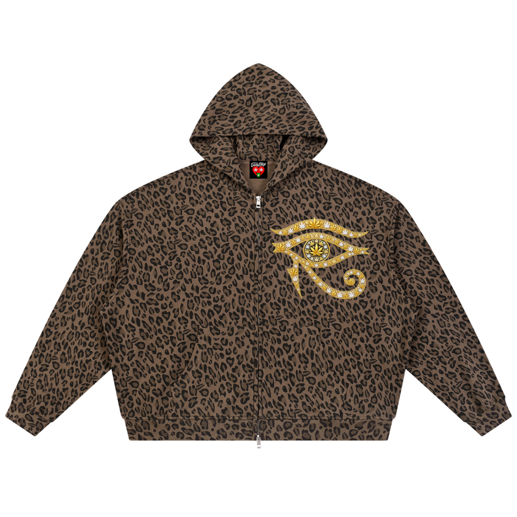 A brown and black leopard print zip-up hoodie featuring a large gold and yellow Eye of Horus graphic on the left chest, displayed against a solid white background.