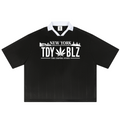 A black short-sleeve polo shirt with a white collar and a white graphic print on the chest reading 'NEW YORK TDY BLZ' with a cannabis leaf and 'THE EMPIRE STATE' underneath.