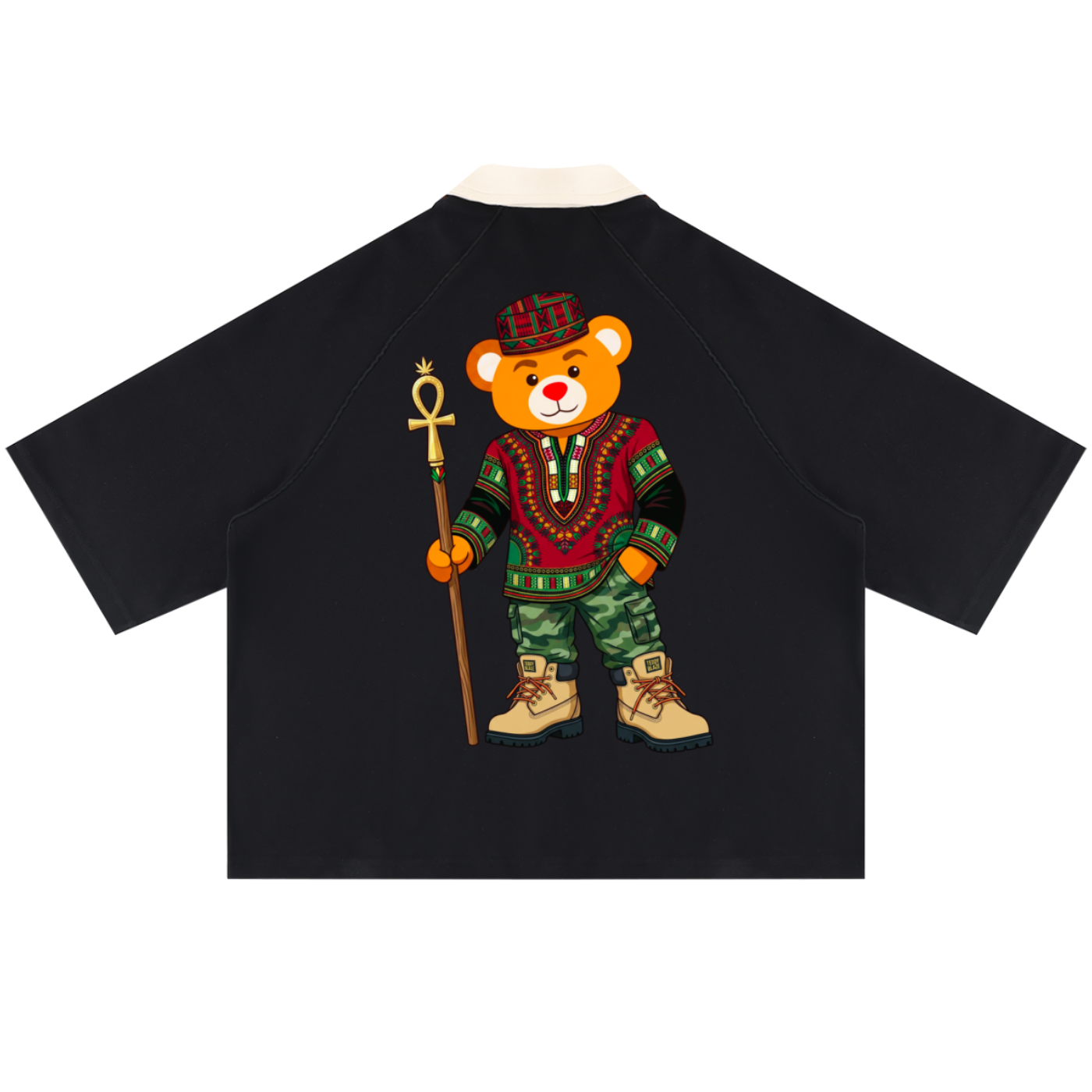A black raglan-style short-sleeve shirt shown from the back, featuring a large graphic of a teddy bear dressed in colorful traditional African clothing and holding a staff, on a plain white background.
