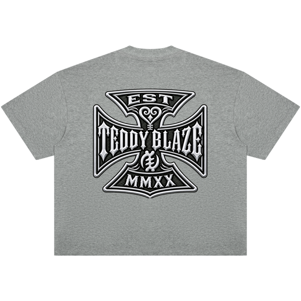 A heather gray short-sleeve t-shirt shown from the back, featuring a large black and white graphic print of an Iron Cross style emblem with the text 'EST TEDDY BLAZE MMXX'.