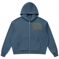 A slate blue cropped zip-up hoodie with a gold glittery 'Teddy Blaze' graphic on the left chest, displayed on a clean white background.