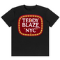 A black short-sleeve crewneck t-shirt featuring a large graphic print on the chest. The graphic is a red rounded rectangle with a gold patterned border and white text reading 'TEDDY BLAZE BRAND NYC'.