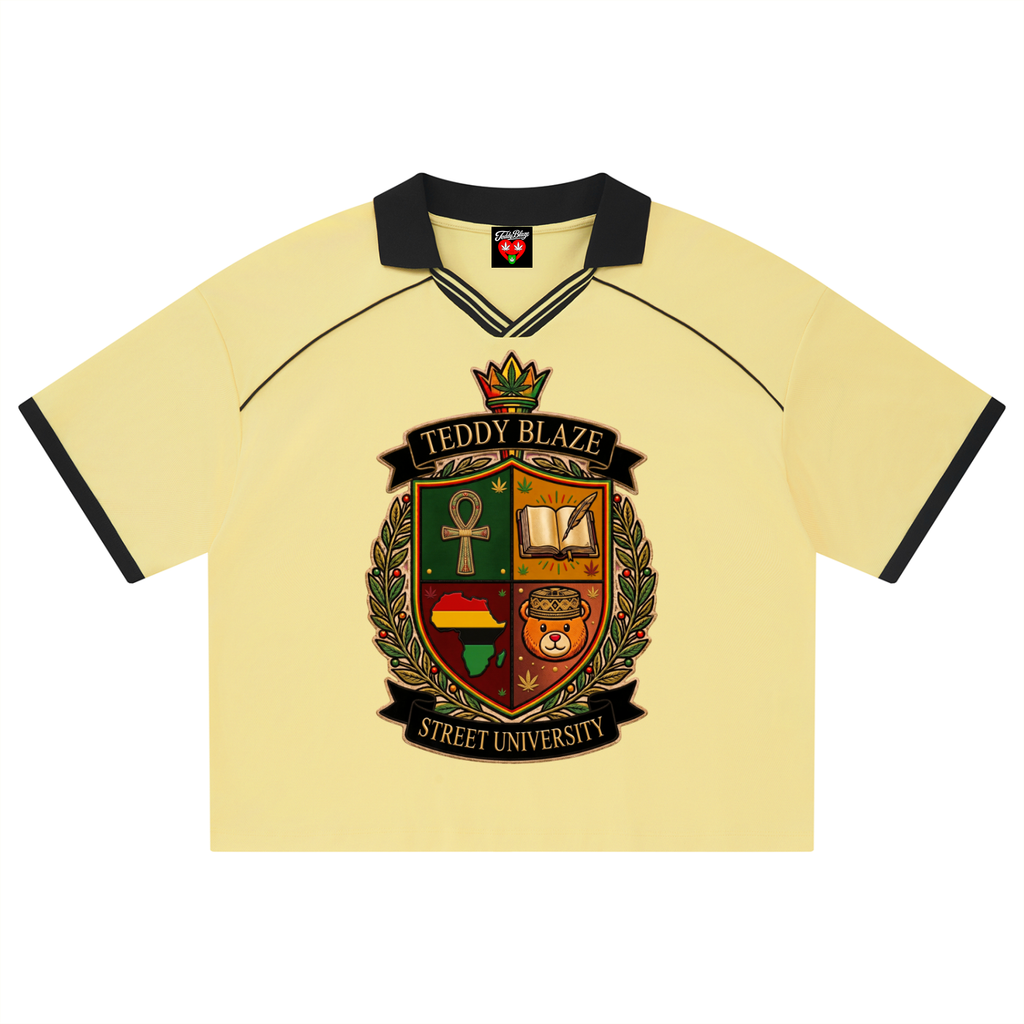 A pale yellow short-sleeve polo shirt with black collar and sleeve trim, featuring a large 'Teddy Blaze Street University' crest printed on the front.