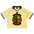 A pale yellow short-sleeve polo shirt with black collar and sleeve trim, featuring a large 'Teddy Blaze Street University' crest printed on the front.