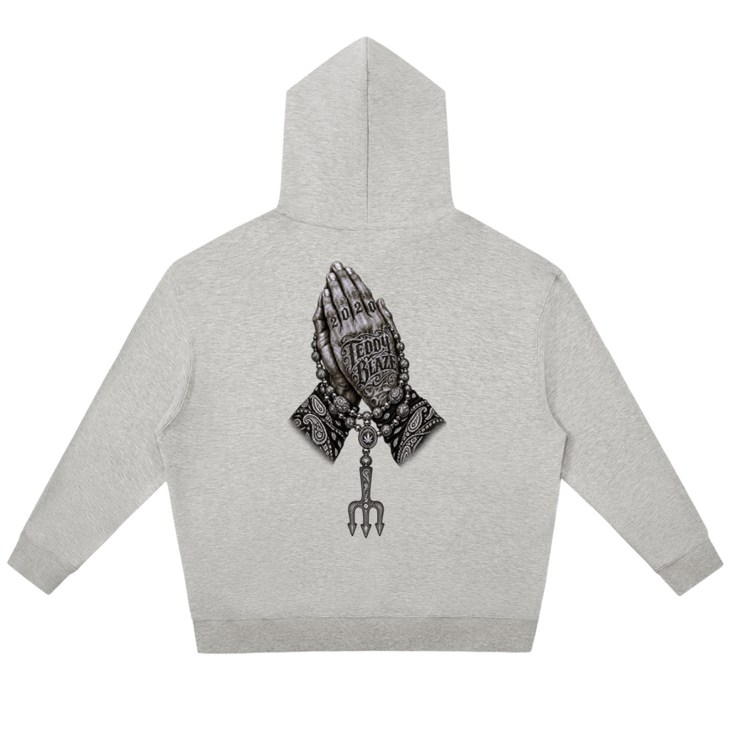 Elevate your cool-weather layers with the Teddy Blaze Sin City Relaxed Pullover Hoodie. Heather gray fleece hoodie with Sin City front print and tattoo praying hands back graphic. Shop NYC to Vegas style.