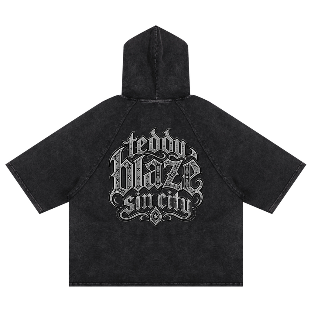 Elevate your casualwear with the Teddy Blaze Sin City Snow Washed Hooded Box Cut Tee. Charcoal snow-washed cotton blend, short raglan sleeves, hood, and tattoo praying hands graphic. Shop NYC to Vegas style.