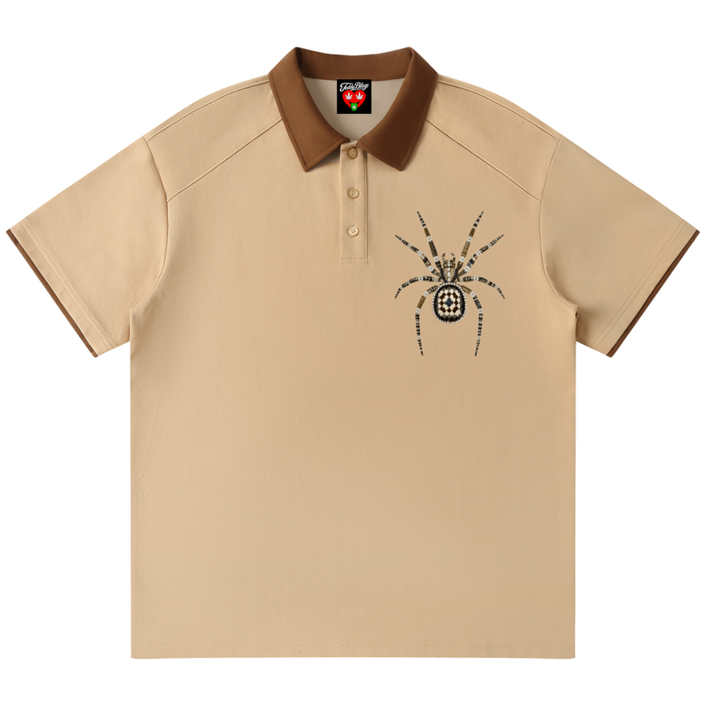 A beige short-sleeve polo shirt with a brown collar and sleeve trim, featuring a black spider graphic on the left chest. The shirt is displayed flat against a solid white background.