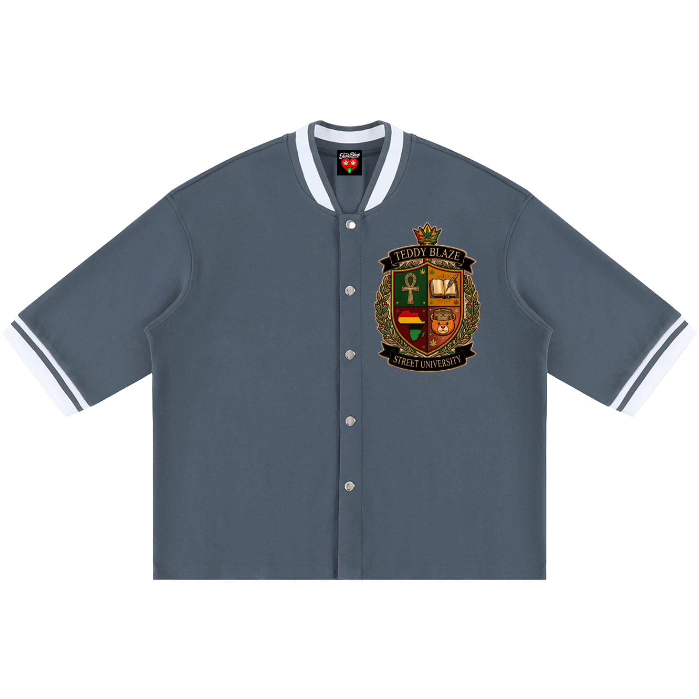 A slate blue short-sleeve varsity-style button-up shirt with white striped collar and cuffs, featuring a detailed multicolor crest on the left chest.