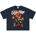 A navy blue short-sleeve t-shirt with a graphic print of a samurai bear wearing a flame helmet and wielding a sword, with the text 'Teddy Blaze' in white script above and Japanese characters below.