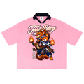 A light pink short-sleeve polo shirt with a black collar, featuring a large graphic of a cartoon bear character and the text 'Teddy Blaze' on the front, displayed against a solid white background.