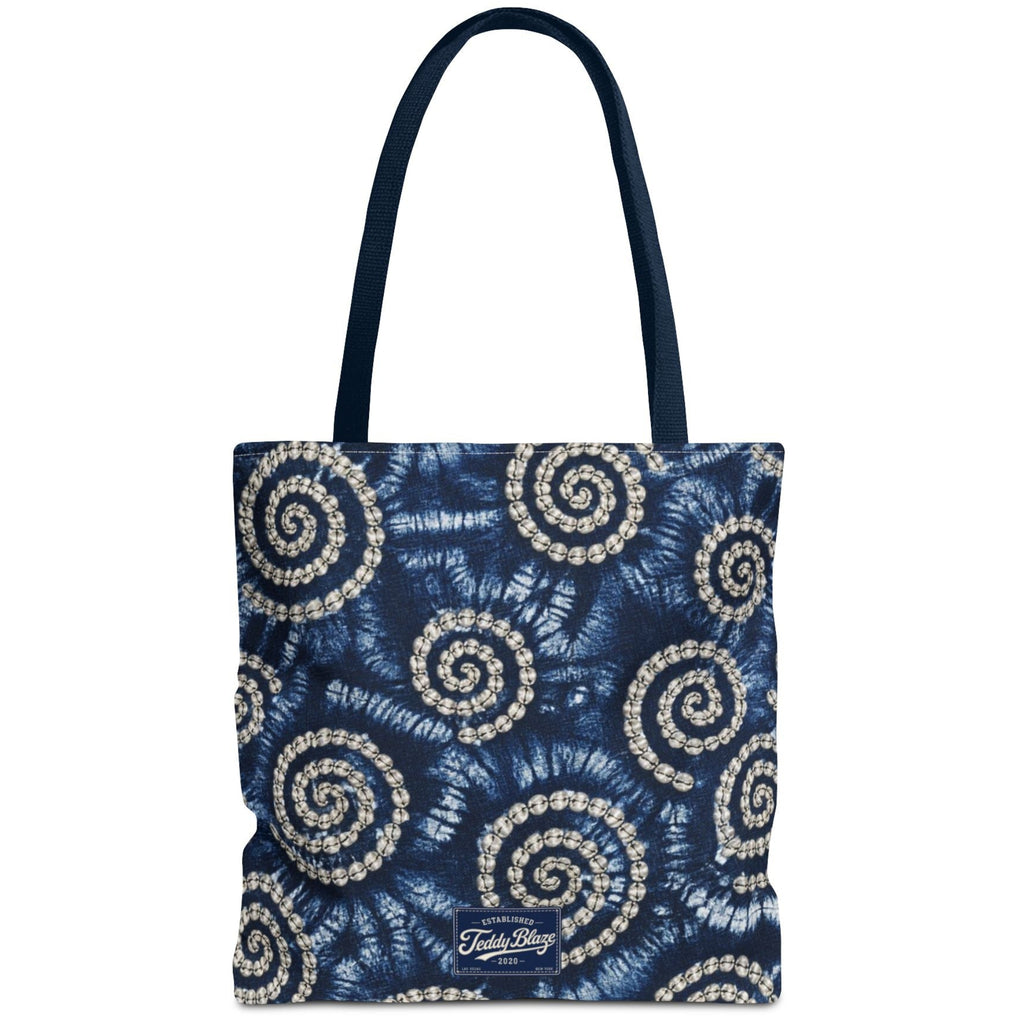 A navy blue tote bag with a white and gray spiral tie-dye pattern, featuring dark navy handles and a small white 'TulaBag' logo patch at the bottom center.