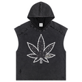 A sleeveless hooded crop top in washed black denim featuring a large white cannabis leaf graphic on the front, displayed against a solid white background.