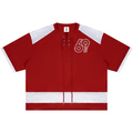 A red short-sleeve knit top with white shoulder panels, a white horizontal stripe at the hem, lace-up front detailing, and a white outlined '69' graphic on the left chest, shown on a plain white background.
