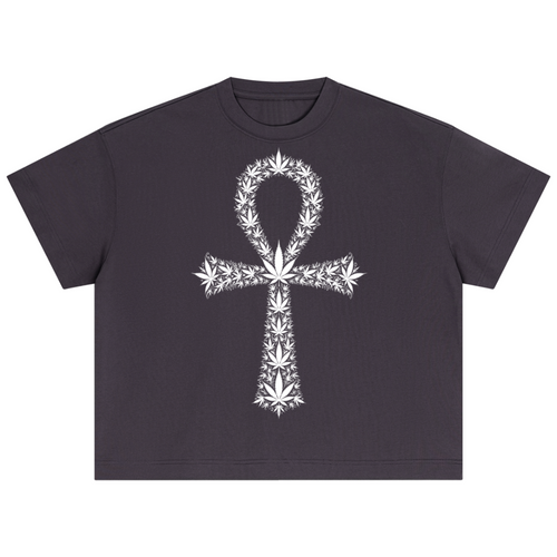 A dark charcoal gray short-sleeve crop top t-shirt featuring a large white graphic of an Ankh symbol composed of cannabis leaves, displayed flat against a solid white background.