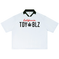 A white short-sleeve polo shirt with a black collar, featuring 'California TDY BLZ' printed on the chest in red and black, with a black cannabis leaf graphic.