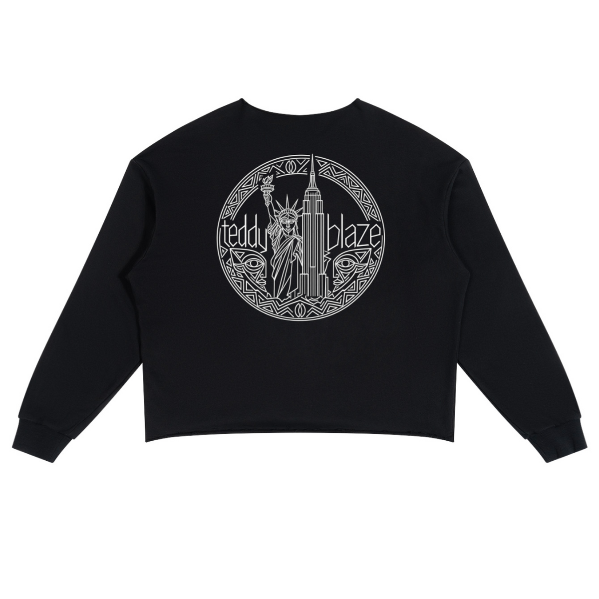 A black cropped sweatshirt with long sleeves, shown flat against a white background. The back of the sweatshirt features a large circular graphic in white, depicting the Statue of Liberty and the New York City skyline with the text 'teddy blaze'.