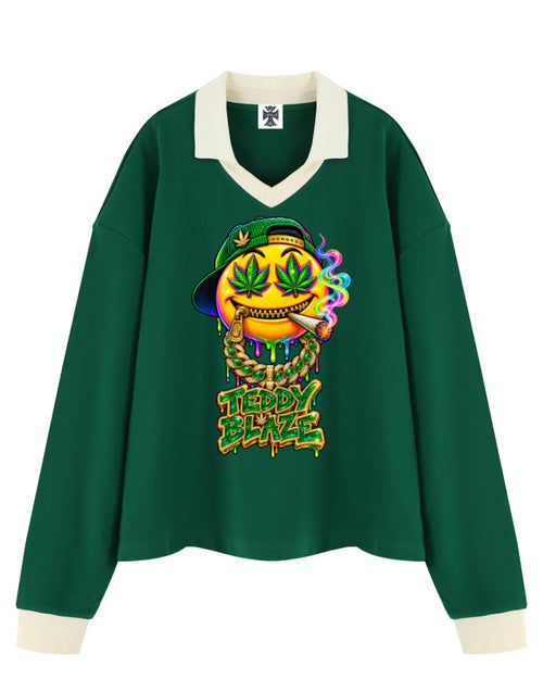 Shop the Iron + Ivy Bakey Face Contrast Trim Long Polo by Teddy Blaze. Heavyweight 320 GSM forest green cotton-poly long-sleeve polo featuring a vibrant melting smiley face graphic and cream contrast collar.