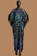 A floor-length black caftan-style dress with wide draped sleeves and an allover sequined geometric pattern, displayed on a black mannequin against a warm tan studio backdrop.