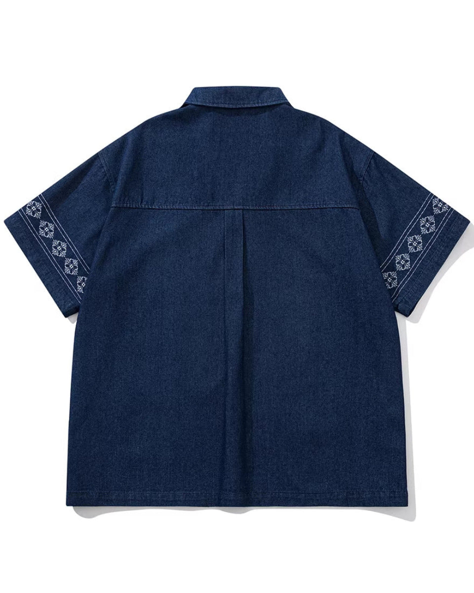 Shop the Iron + Ivy Border-Printed Denim Cuban Collar Shirt by Teddy Blaze. Men’s loose-fit indigo denim short-sleeve shirt featuring floral border sleeve prints