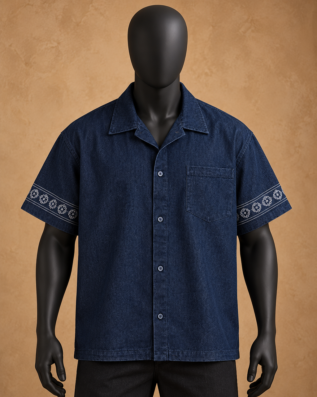 A dark blue short-sleeve button-up shirt with white geometric patterns on the sleeve cuffs, displayed on a black mannequin against a textured tan background.