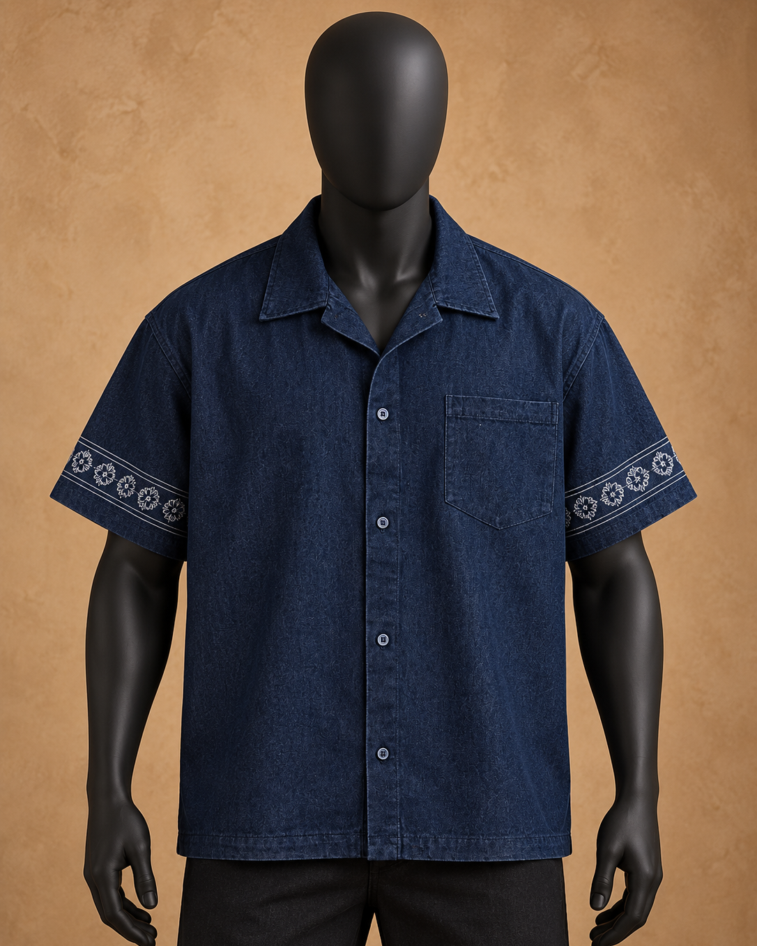 A dark blue short-sleeve button-up shirt with white geometric patterns on the sleeve cuffs, displayed on a black mannequin against a textured tan background.