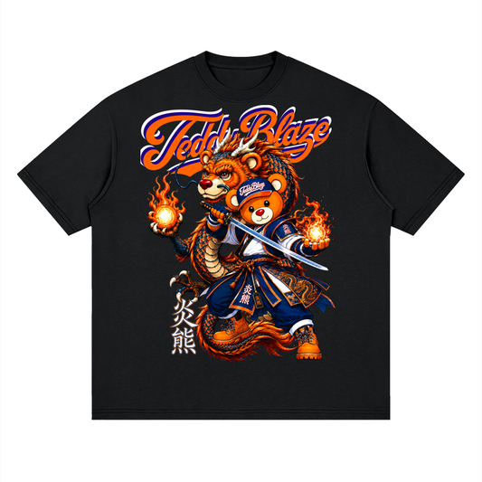 A black short-sleeve crewneck t-shirt featuring a large graphic print of a cartoon bear wearing a blue samurai outfit and holding a sword, with flames on both sides. The text 'Teddy Blaze' is written above in orange and white, with vertical Japanese characters below.