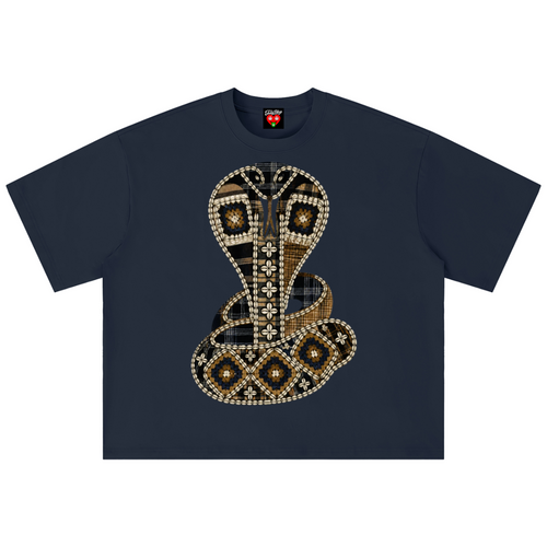 A navy blue short-sleeve t-shirt featuring a large, detailed graphic of a coiled cobra snake on the front. The snake is decorated with geometric patterns made of white dots, black and brown plaid, and gold accents.
