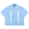 Powder-blue 100% cotton boxy Cubano shirt with twin Afrodemia graphics, relaxed unisex proportions and signature VERY TEDDY back branding.