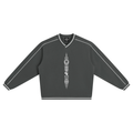A charcoal collegiate V-neck jumper with contrast piping, striped trim and Teddy Blaze Afrodemia Americana artwork. Premium Afrocentric everyday sportswear.