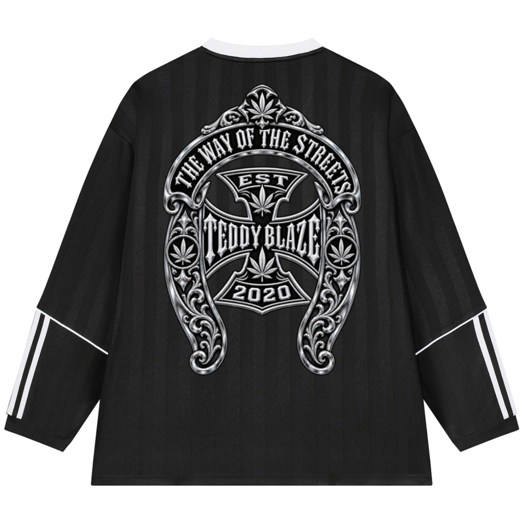 Black long-sleeve shirt with a large silver graphic on the back reading 'THE WAY OF THE STREETS TEDDY BLAZE EST 2020' and white stripe details on the sleeves, shown on a white background.