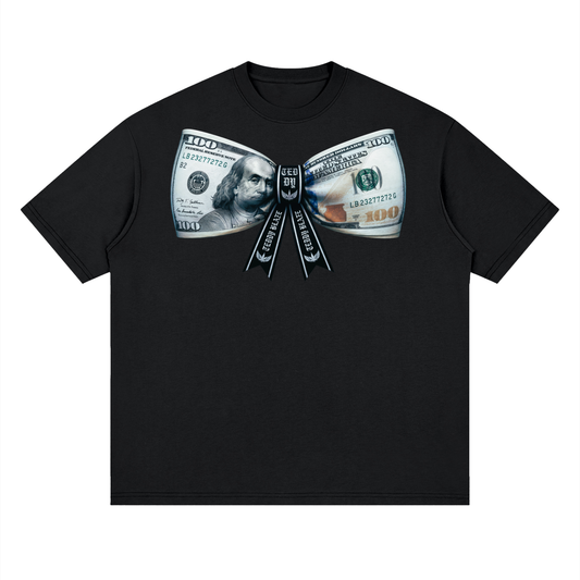 A black short-sleeve crewneck t-shirt featuring a graphic print of a dollar bill ribbon bow made of US $100 bills, with the words 'I LOVE YOU' printed down the center.