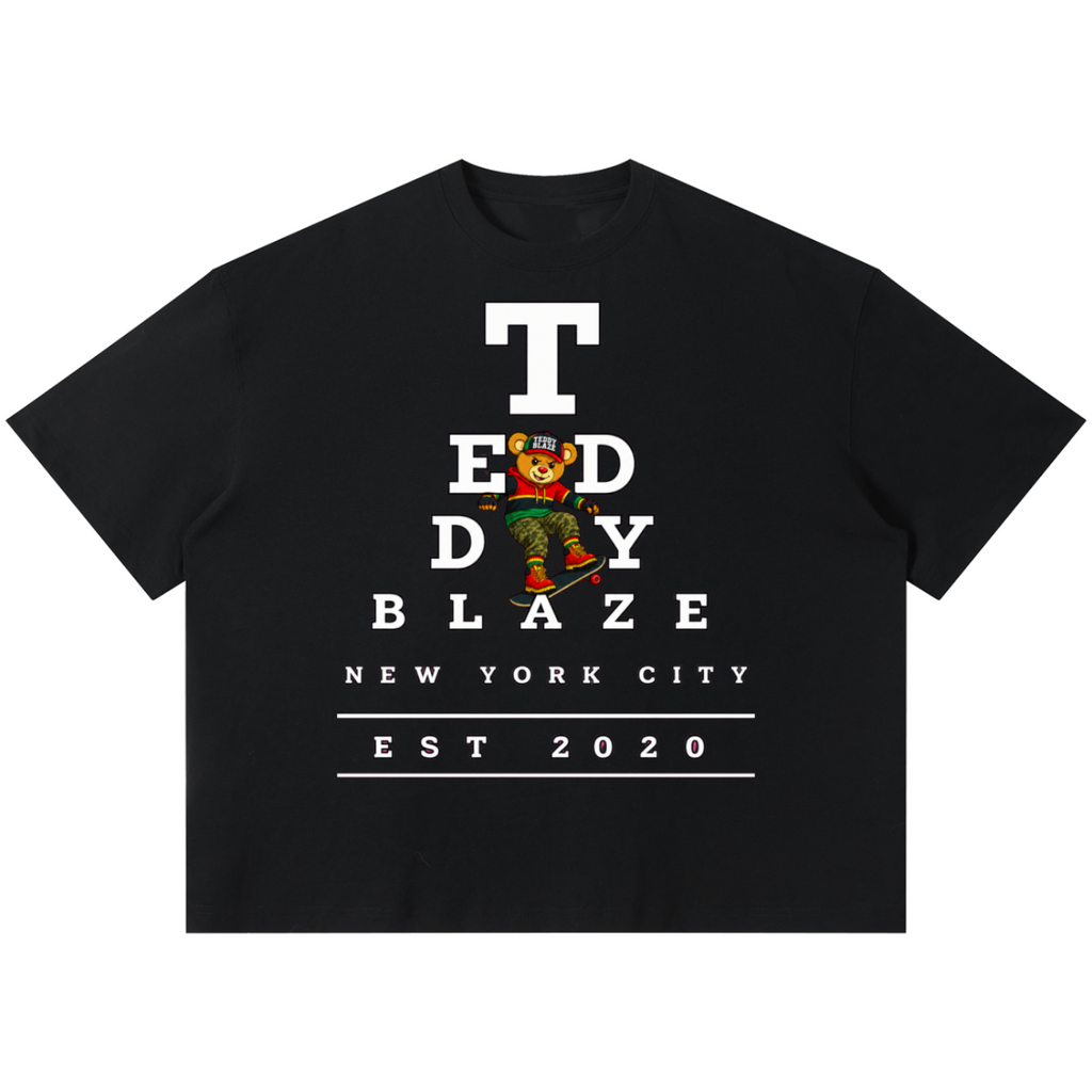 Shop the Boxy Eyechart Tee by Teddy Blaze. 220 GSM cotton-poly oversized drop-shoulder t-shirt with Snellen eye chart graphic from TOPS BY TEDDY BLAZE.